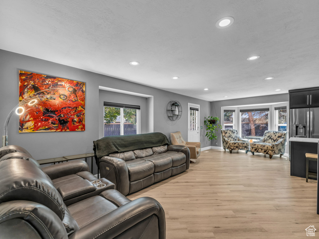 Living room with recessed lighting, light wood-style flooring, and baseboards