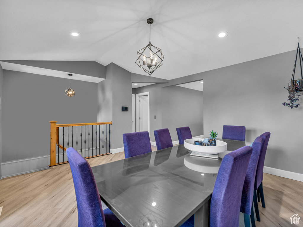 Dining space featuring a chandelier, wood finished floors, lofted ceiling, baseboards, and recessed lighting