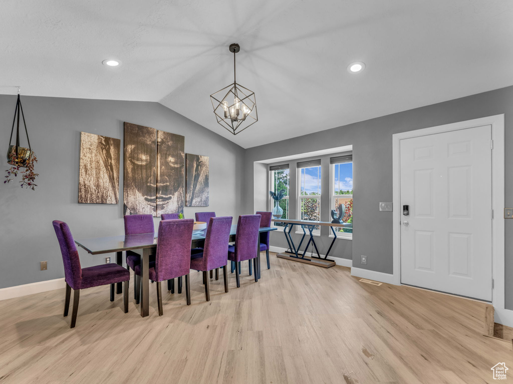 Dining area with wood finished floors, baseboards, a chandelier, lofted ceiling, and recessed lighting