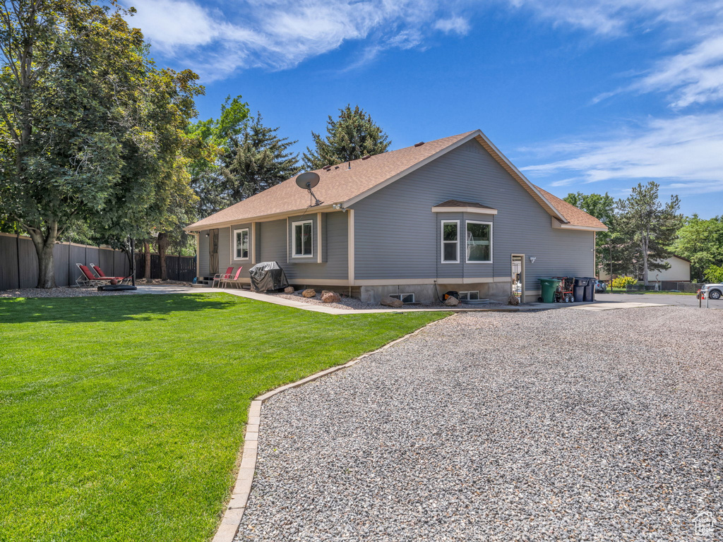 Back of property with roof with shingles and a patio