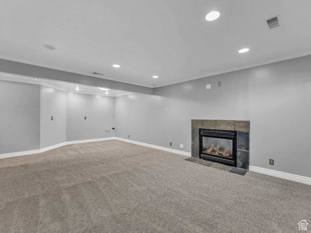 Unfurnished living room with recessed lighting, carpet floors, a fireplace, ornamental molding, and baseboards