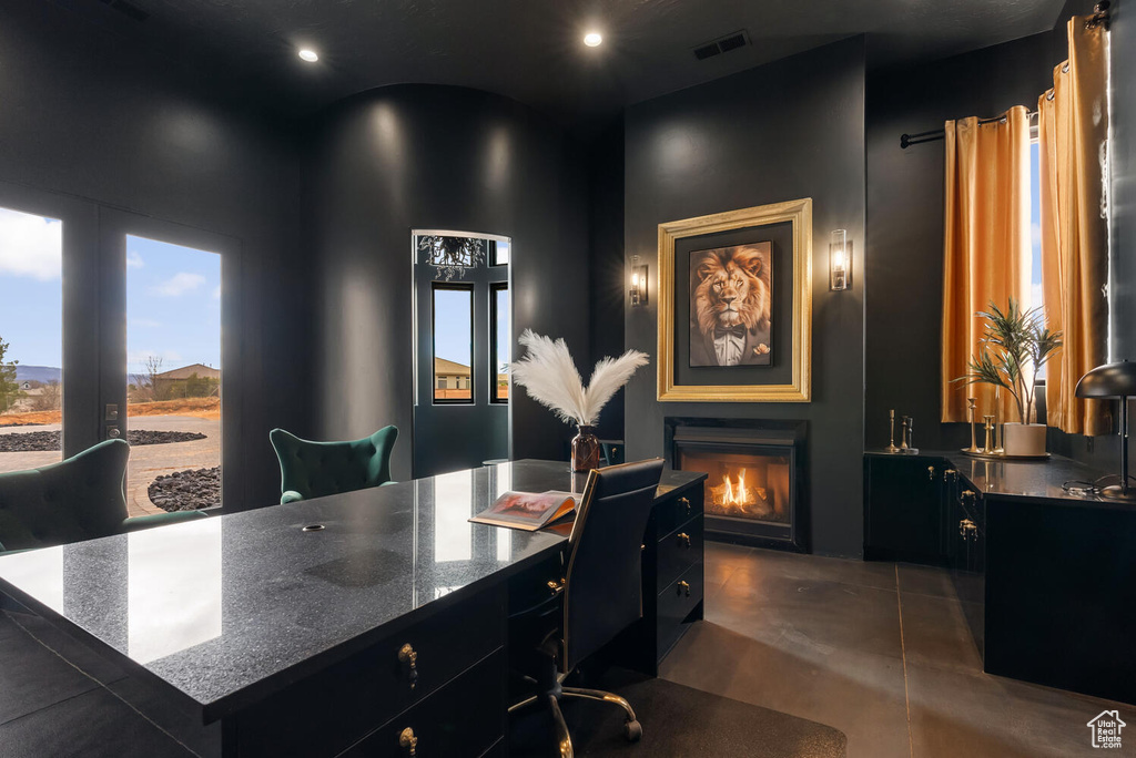Office area featuring a lit fireplace, concrete floors, and recessed lighting