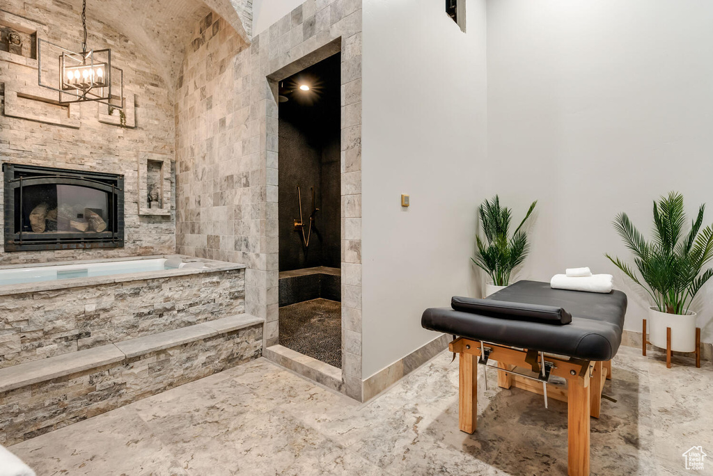 Bathroom featuring tiled shower, a garden tub, a fireplace, marble finish floors, and a chandelier