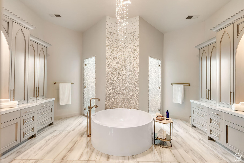 Full bathroom with vanity and a soaking tub
