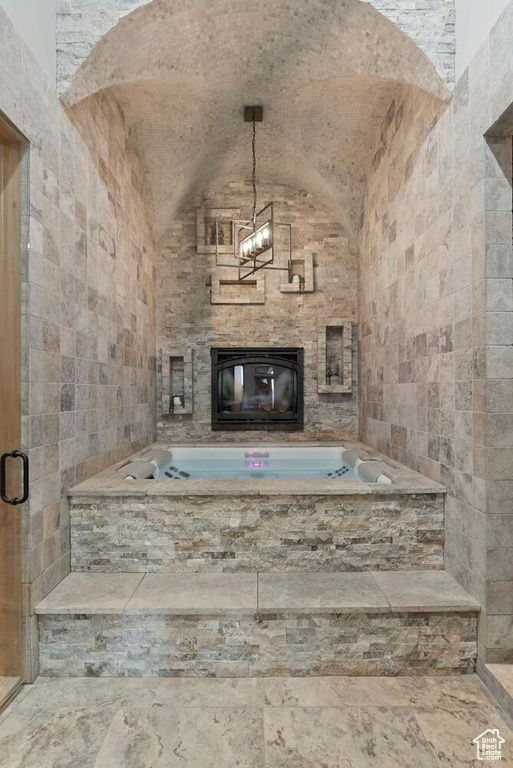 Unfurnished living room with a fireplace, vaulted ceiling, and tile walls