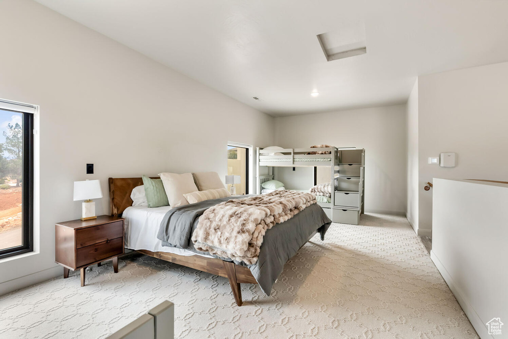 Carpeted bedroom featuring attic access and baseboards