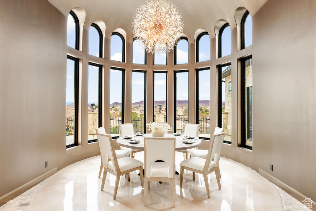 Dining room with a chandelier, a mountain view, and a towering ceiling