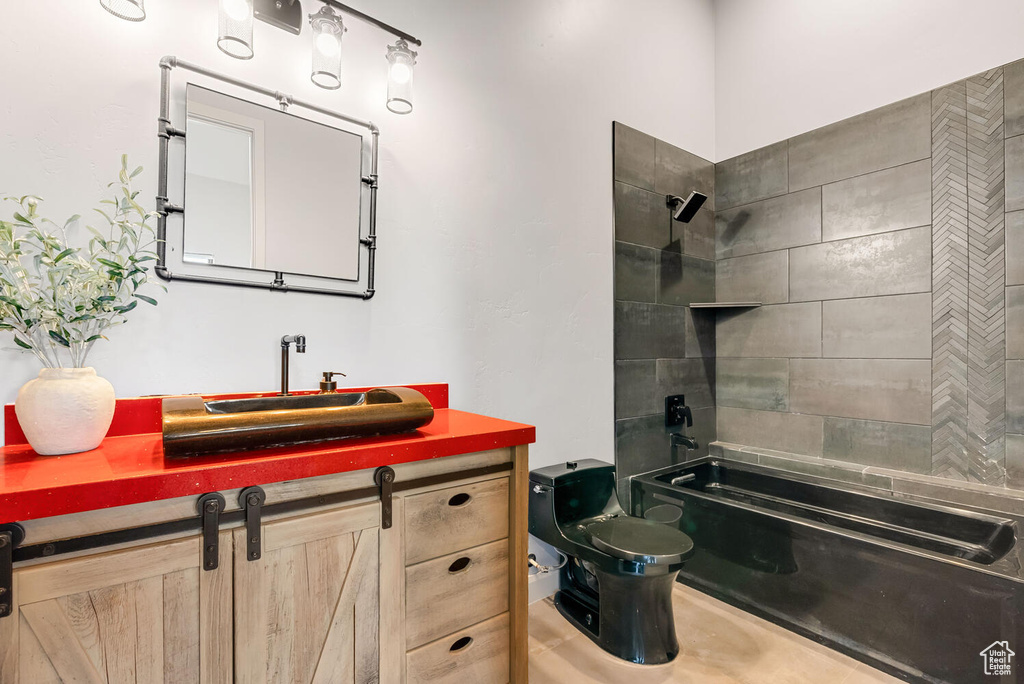 Bathroom featuring toilet, bathtub / shower combination, and vanity