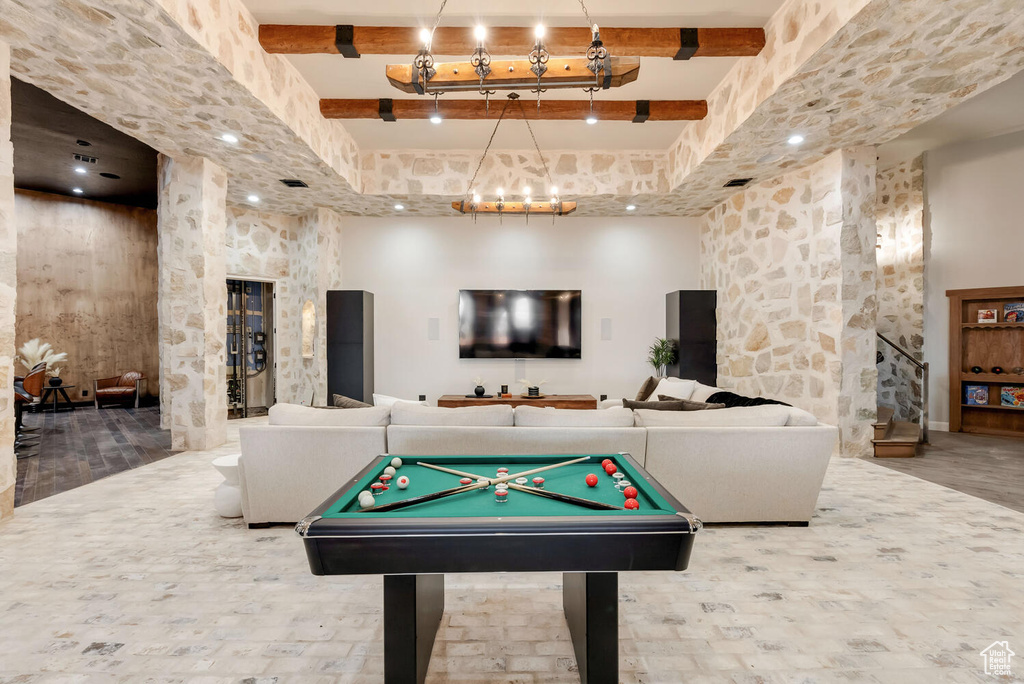 Playroom with a chandelier, beamed ceiling, a high ceiling, and pool table