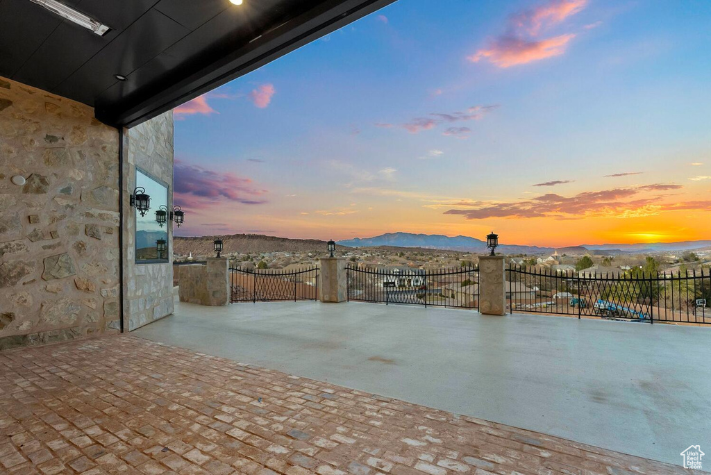 Patio terrace at dusk featuring a mountain view and a patio