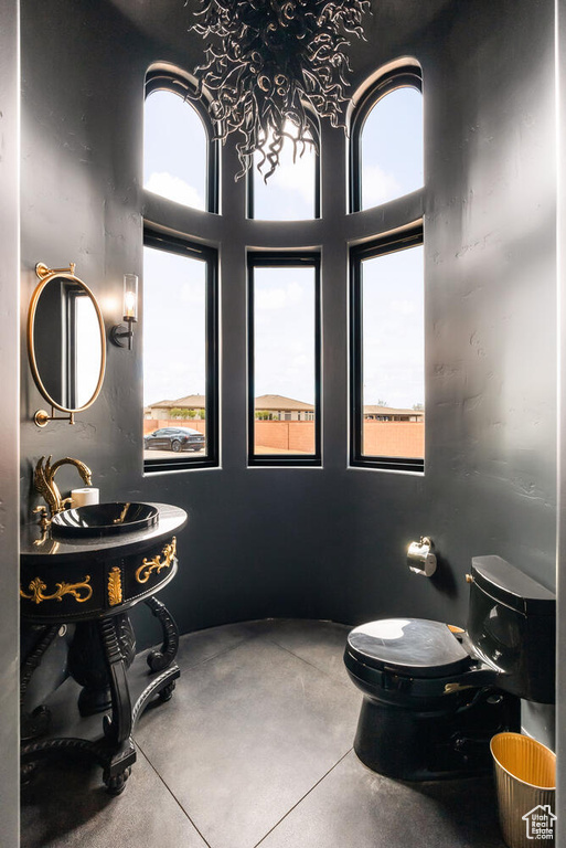 Bathroom with plenty of natural light, finished concrete flooring, and toilet