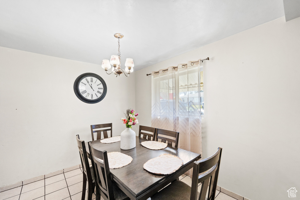 Dining room with a chandelier and light tile patterned flooring