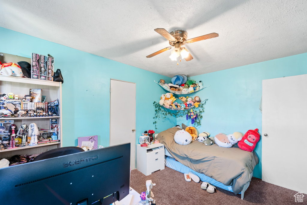 Bedroom featuring carpet floors, a textured ceiling, and ceiling fan
