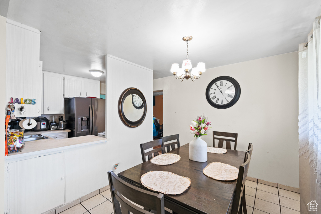 Dining space featuring light tile patterned floors and a chandelier