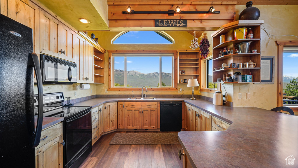 Kitchen with black appliances, open shelves, a sink, dark countertops, and dark wood-style flooring