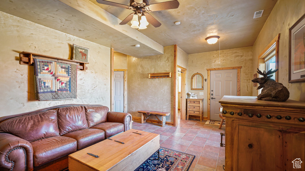 Living room with ceiling fan and stone finish floors