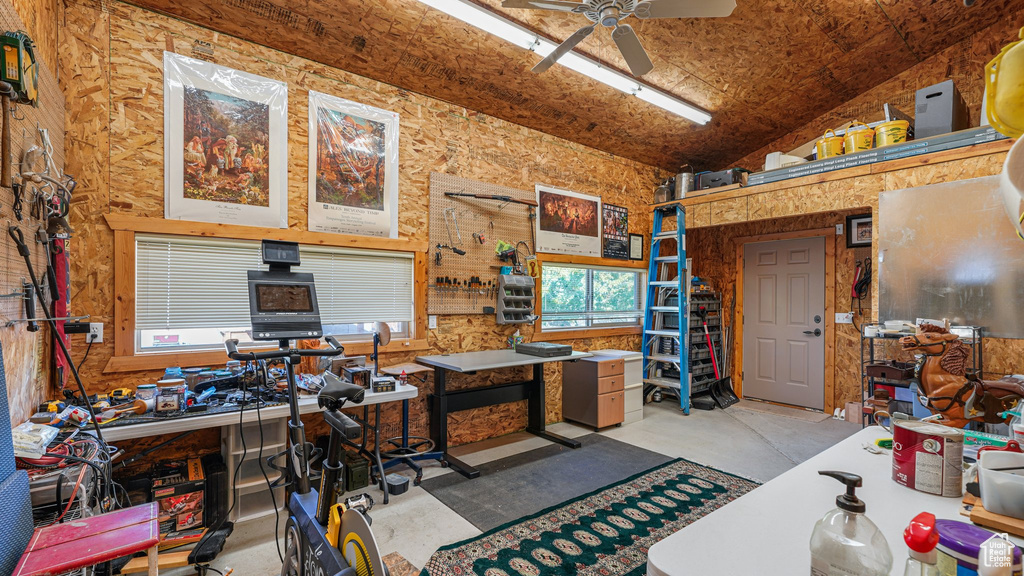 Office featuring a workshop area, concrete floors, a ceiling fan, and high vaulted ceiling