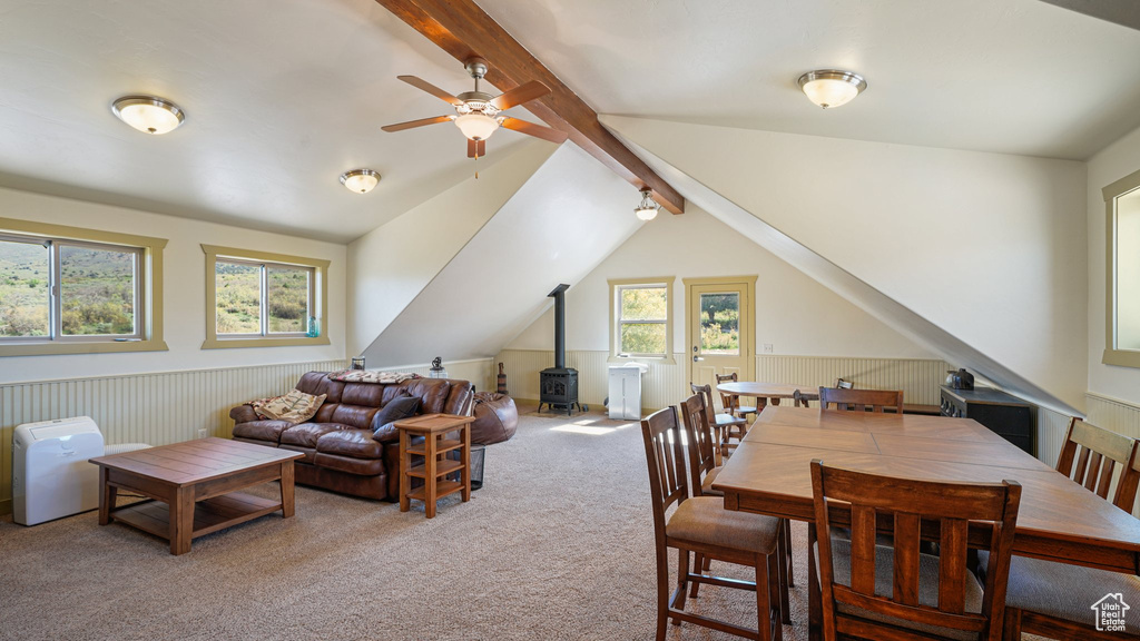 Carpeted living area with a wood stove and a ceiling fan