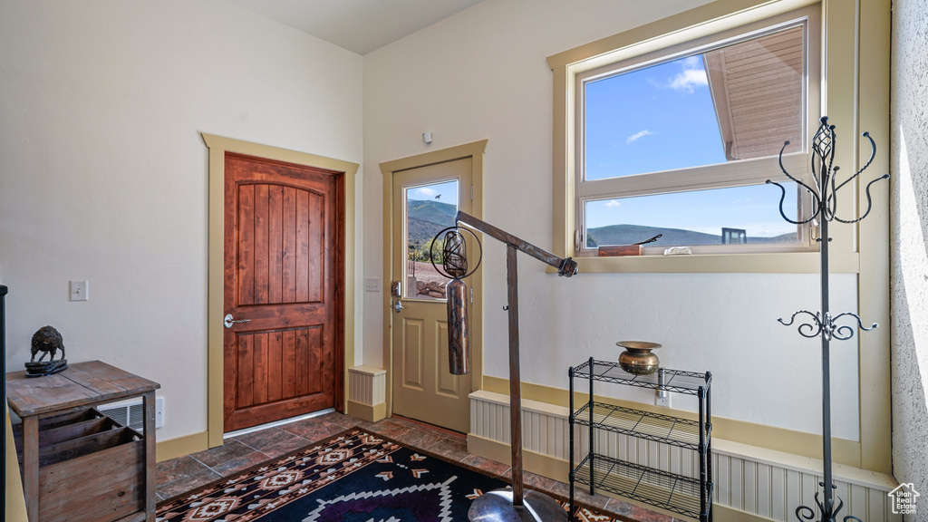 Entryway featuring healthy amount of natural light and stone finish floors