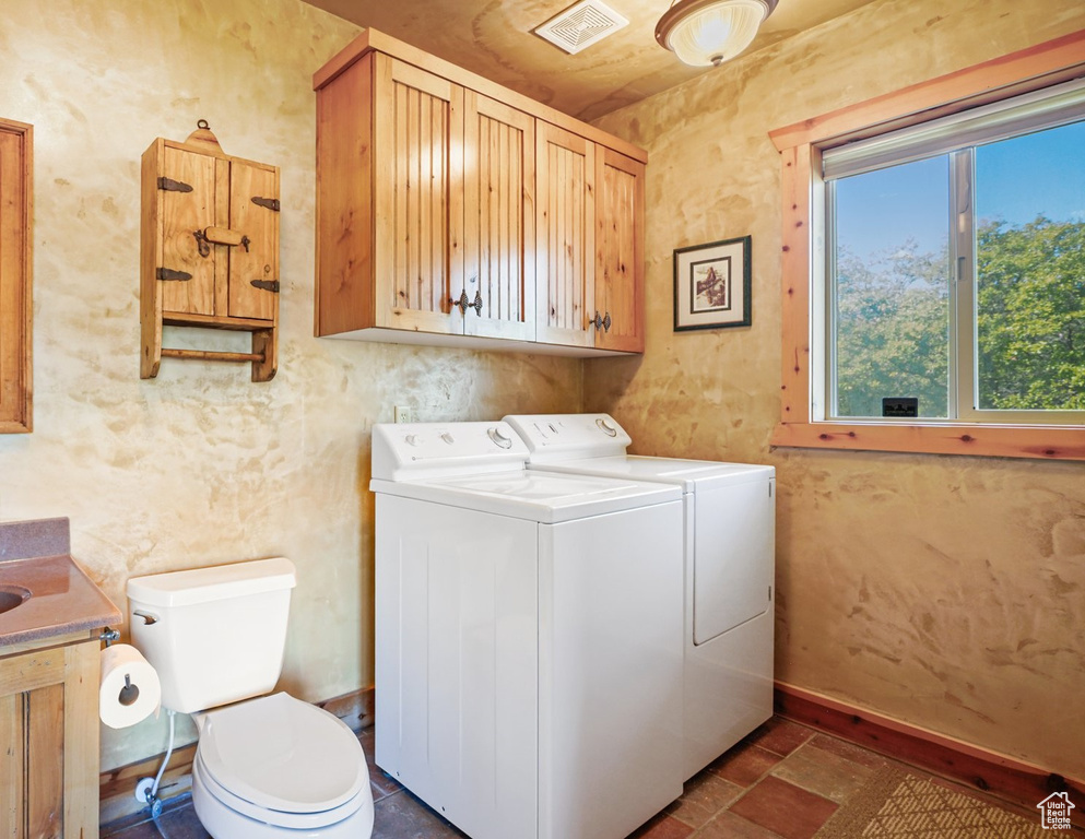 Laundry room featuring washing machine and dryer and baseboards