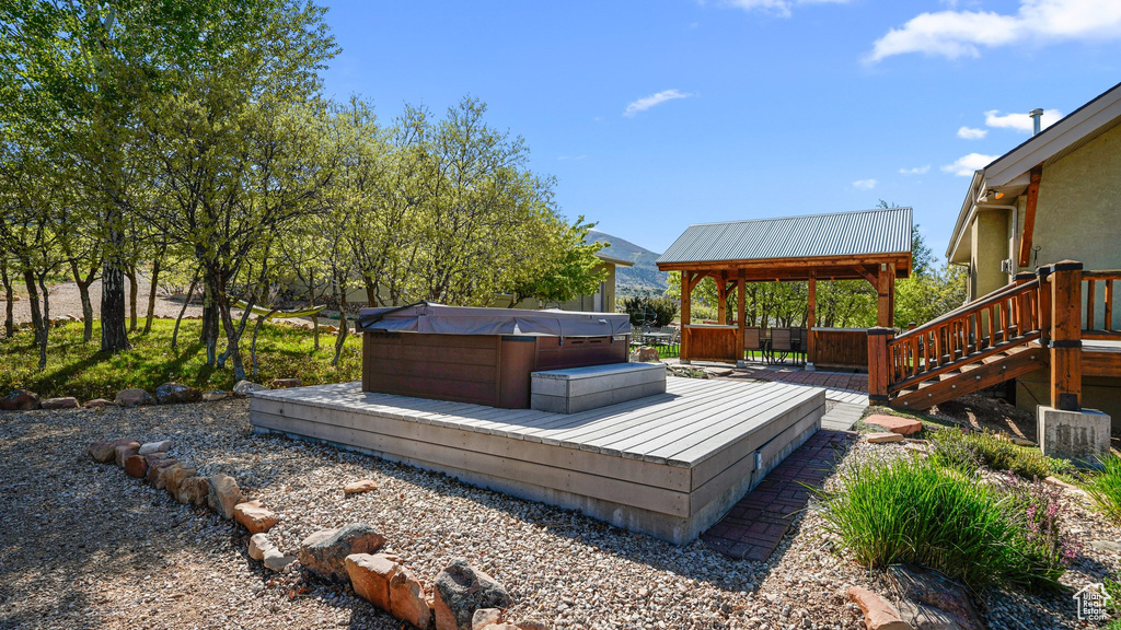 Deck with a hot tub and a gazebo