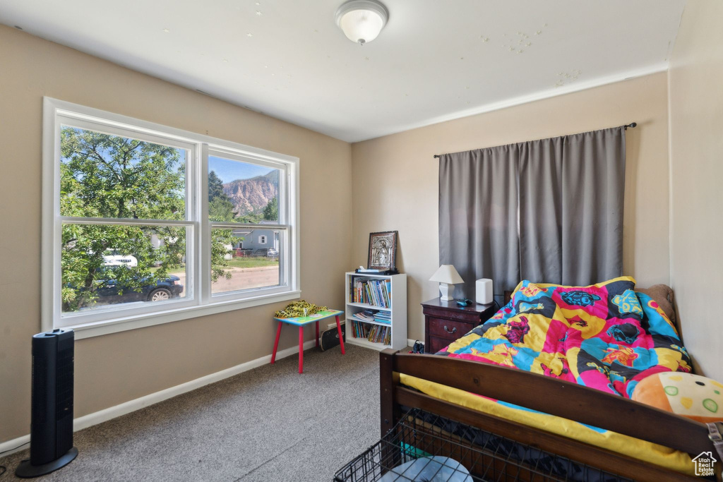 Bedroom featuring carpet and baseboards