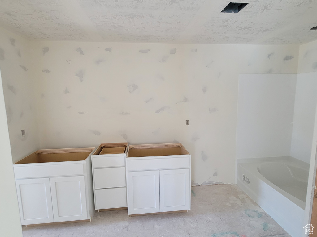 Bathroom featuring a bath and a textured ceiling