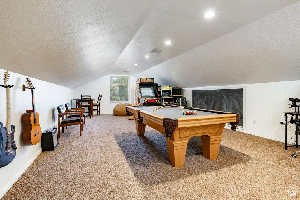 Playroom with light colored carpet, baseboards, pool table, lofted ceiling, and a textured ceiling