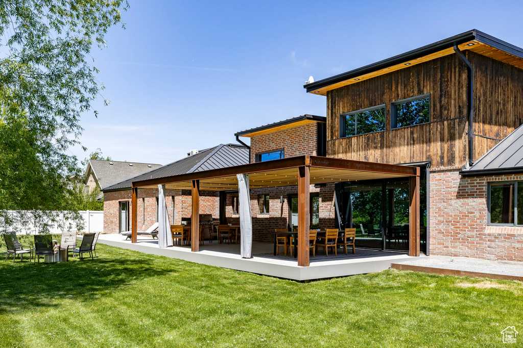Back of house with brick siding and a patio area