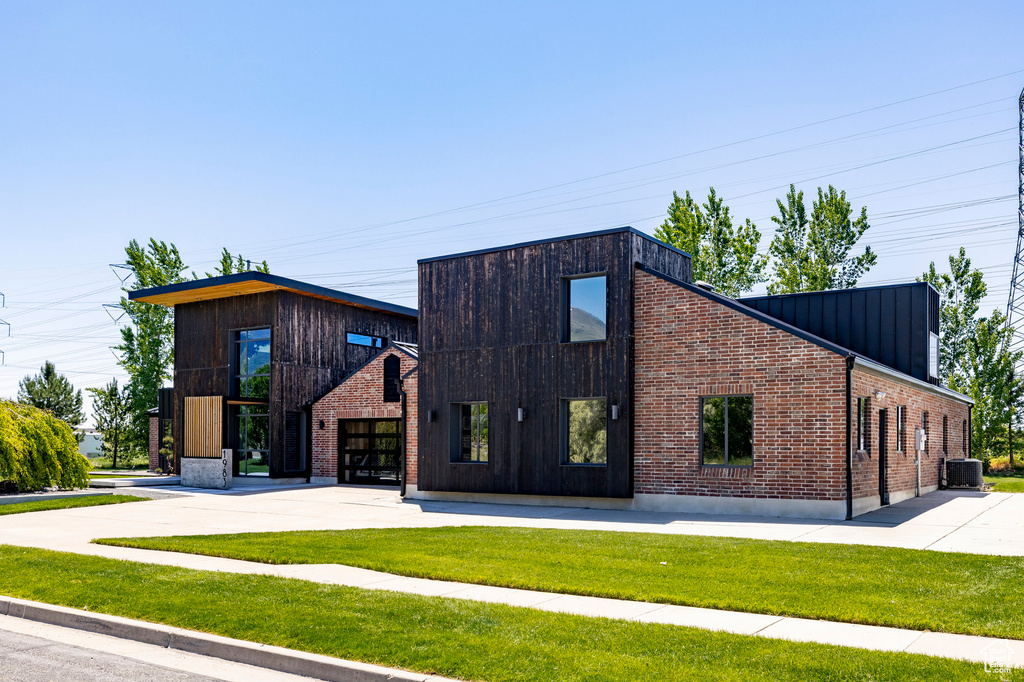 View of building exterior with driveway and cooling unit