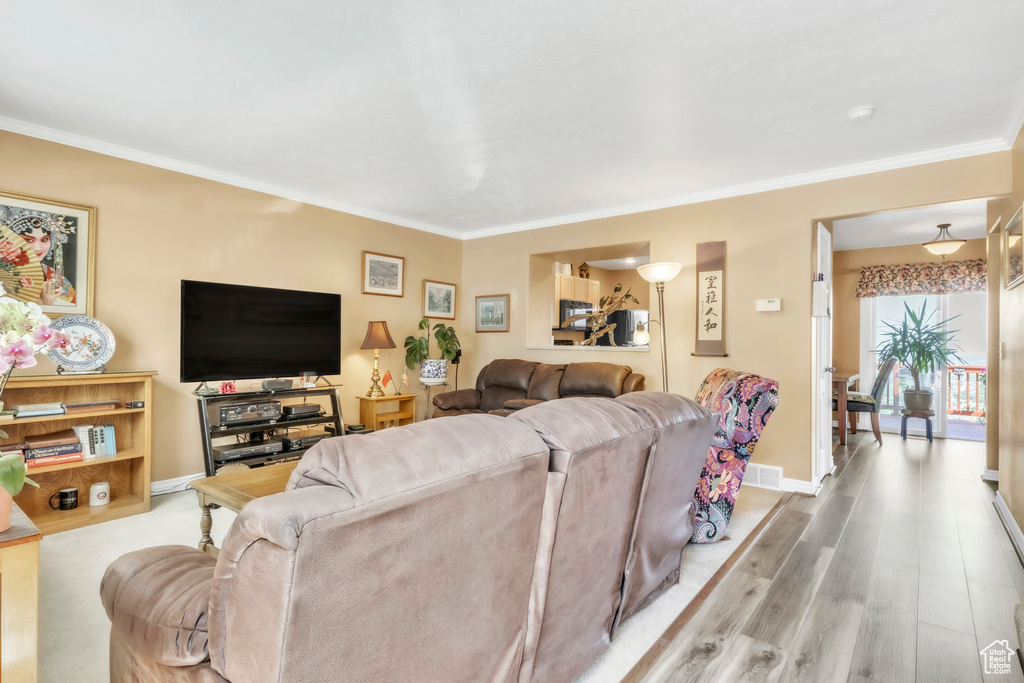 Living room featuring crown molding, wood finished floors, and baseboards