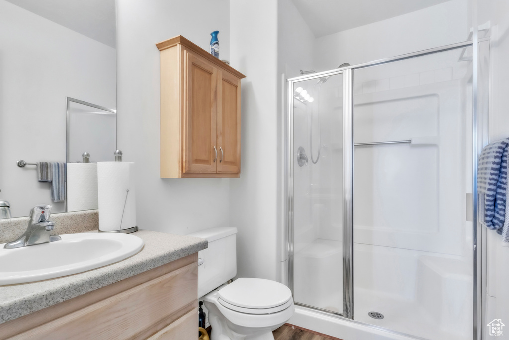 Full bathroom with a shower stall, vanity, and toilet