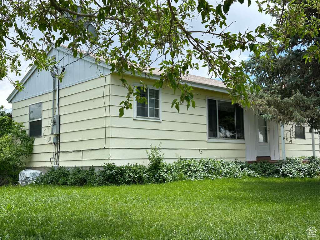 View of side of home featuring a yard
