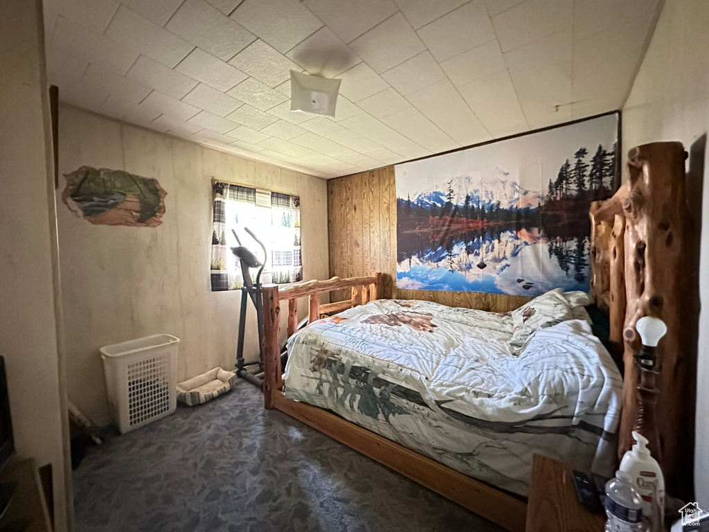 Bedroom featuring carpet and wooden walls