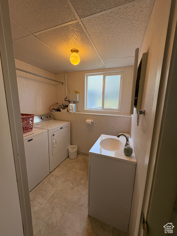 Laundry area featuring washing machine and clothes dryer and wooden walls
