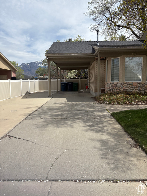 View of parking / parking lot with concrete driveway and a mountain view