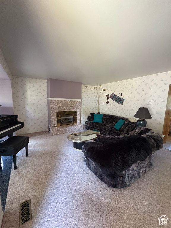 Carpeted living area with wallpapered walls and a high end fireplace