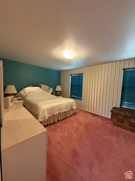 Carpeted bedroom with wallpapered walls