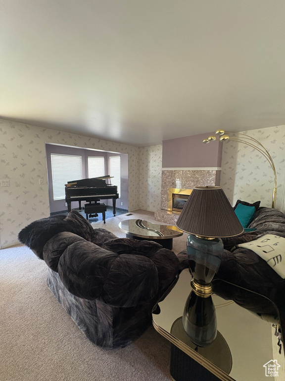 Carpeted living area featuring wallpapered walls and a tiled fireplace