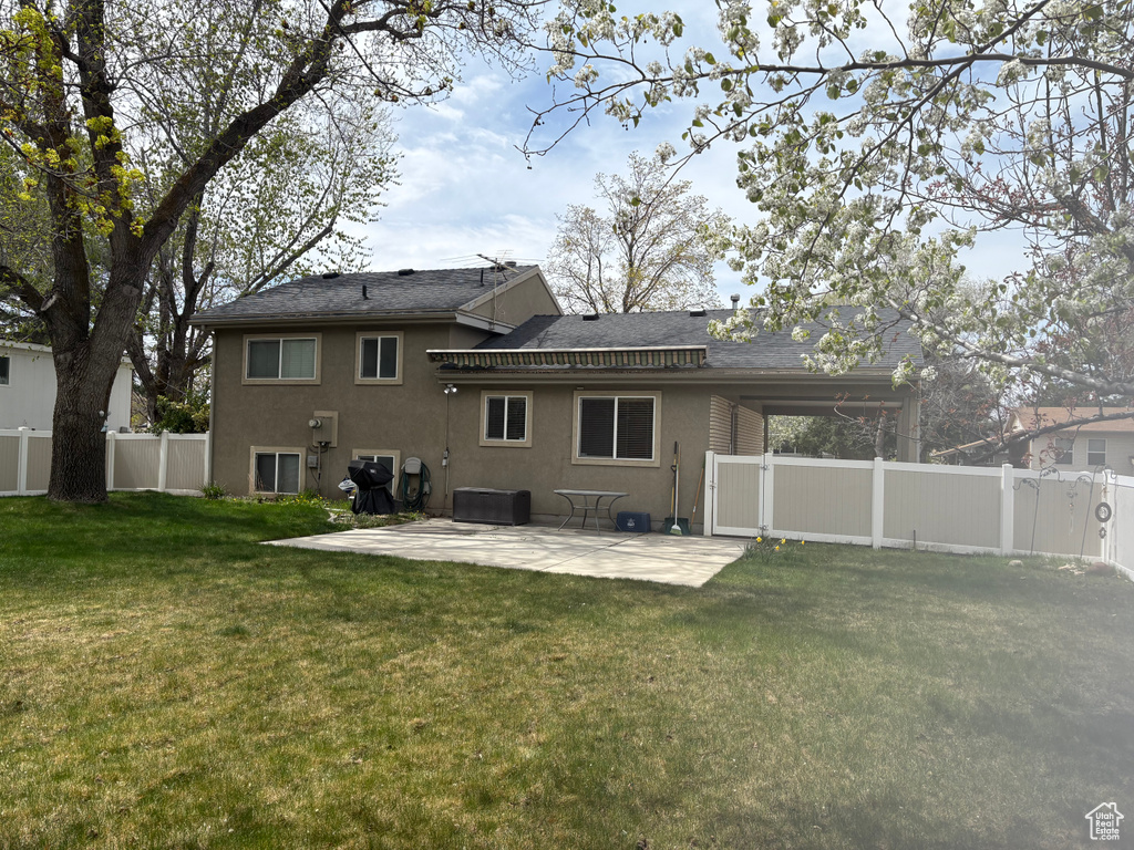 Back of property with stucco siding, a patio area, and roof with shingles