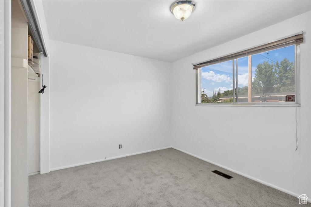 Carpeted spare room with baseboards
