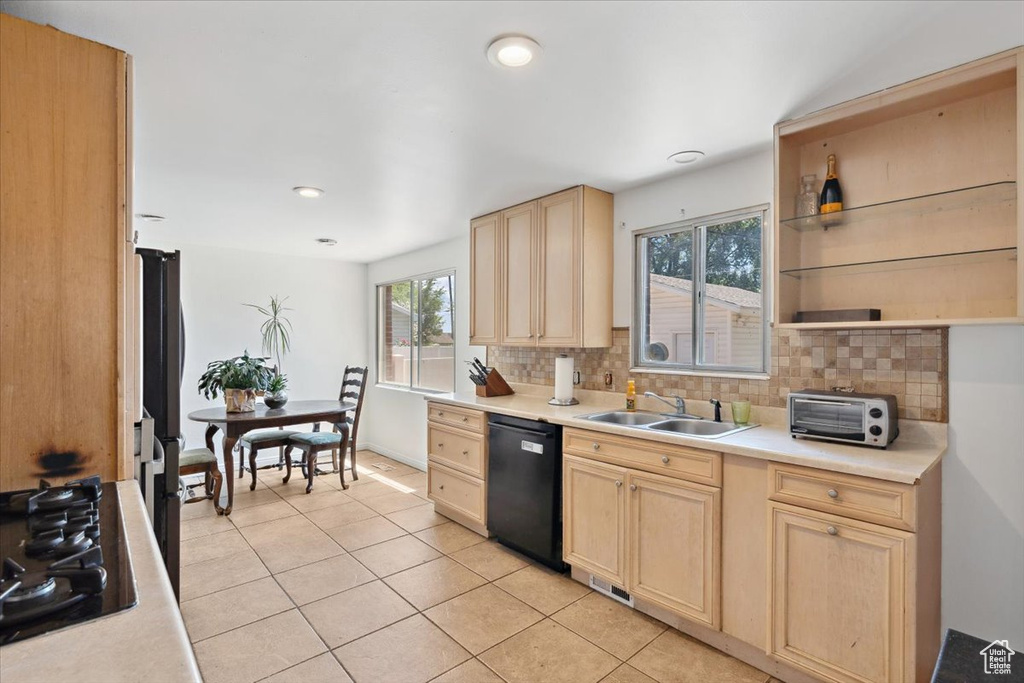 Kitchen featuring black appliances, a sink, light brown cabinetry, decorative backsplash, and recessed lighting