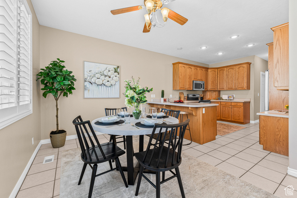 Dining area with light tile patterned floors, ceiling fan, baseboards, and recessed lighting