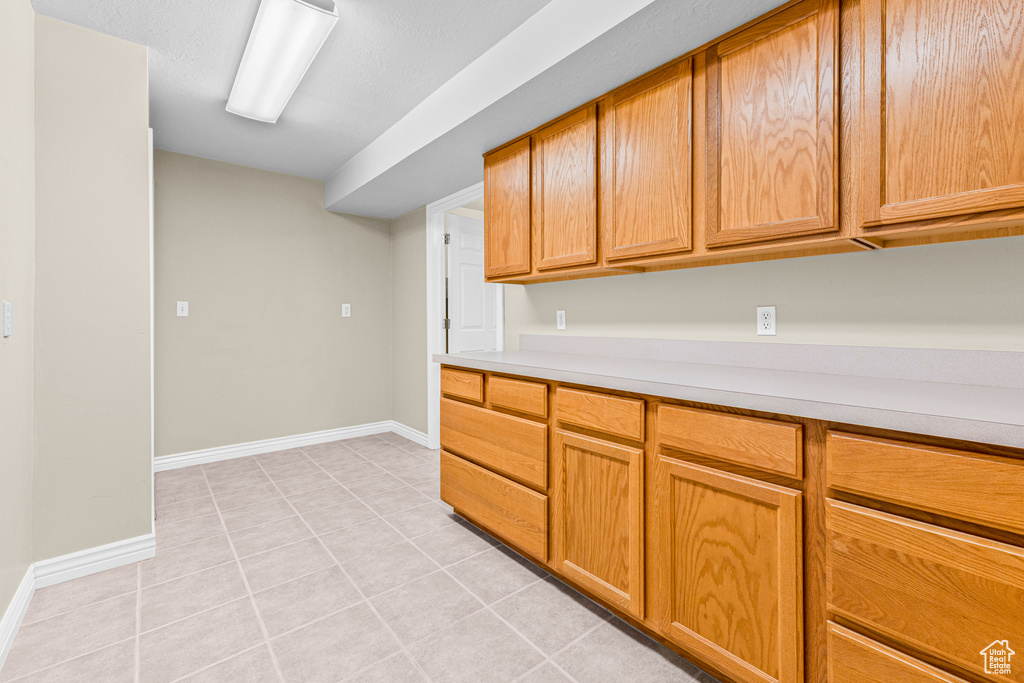 Kitchen featuring light countertops, light tile patterned floors, and baseboards