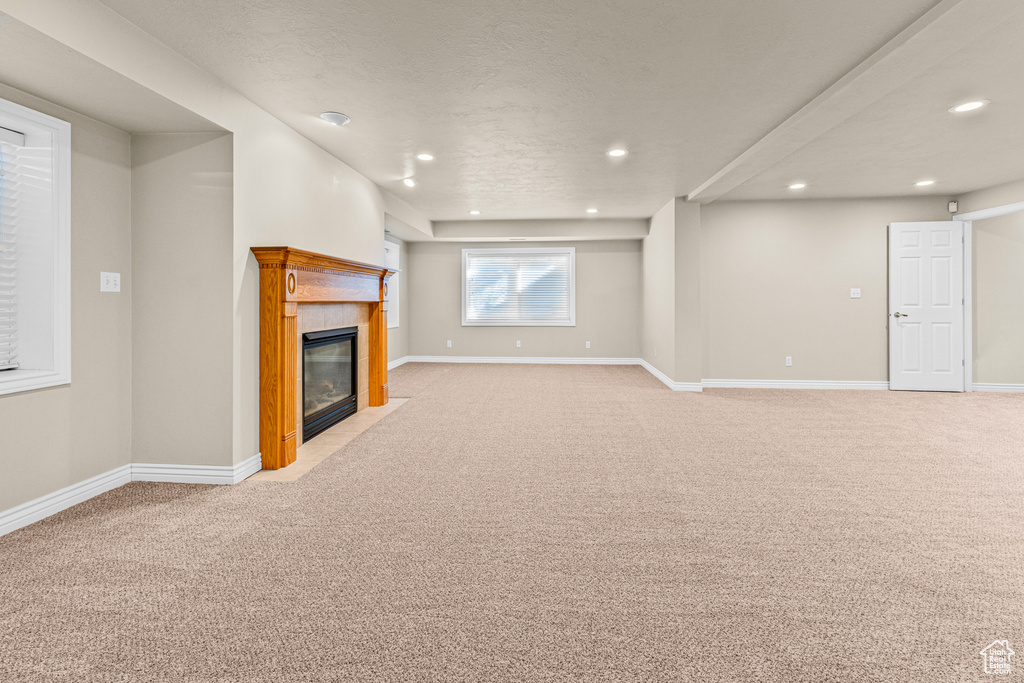 Unfurnished living room featuring light carpet, recessed lighting, a fireplace, and baseboards