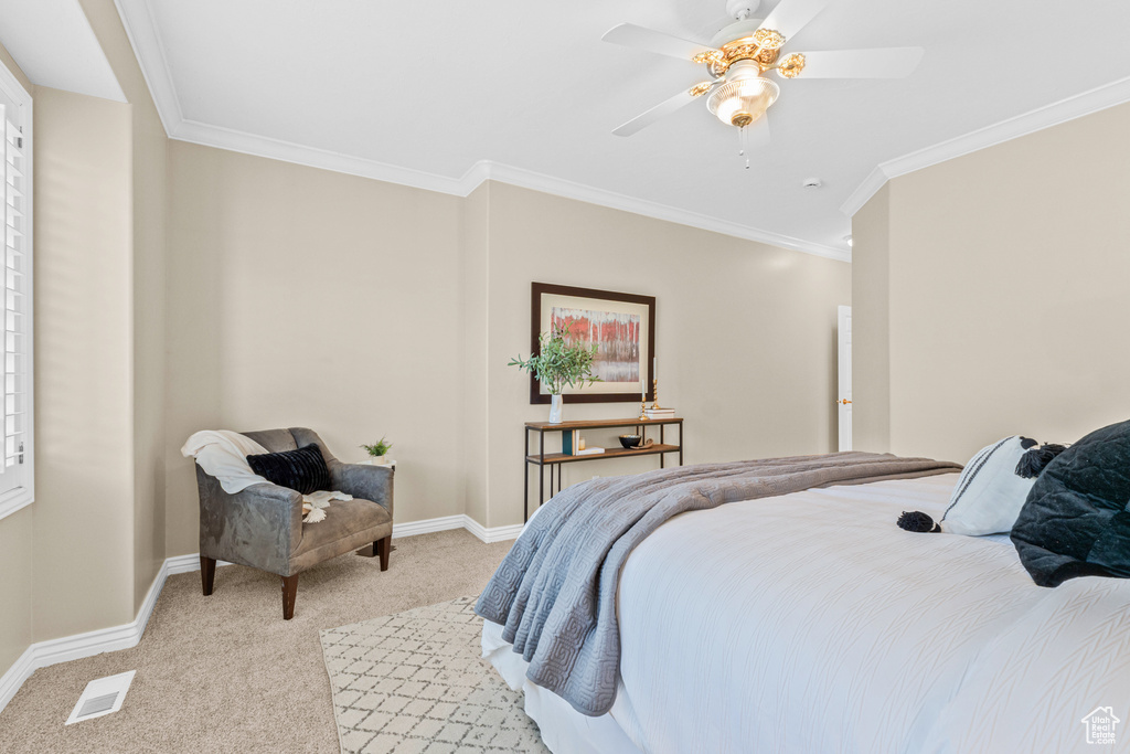 Bedroom featuring light colored carpet, crown molding, baseboards, and a ceiling fan