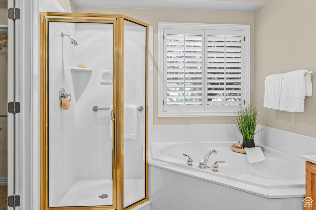 Bathroom with a stall shower, a bath, and vanity