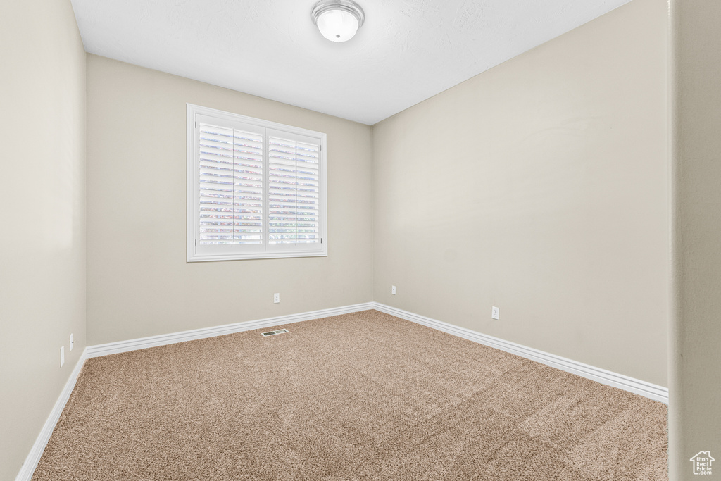 Carpeted spare room with baseboards