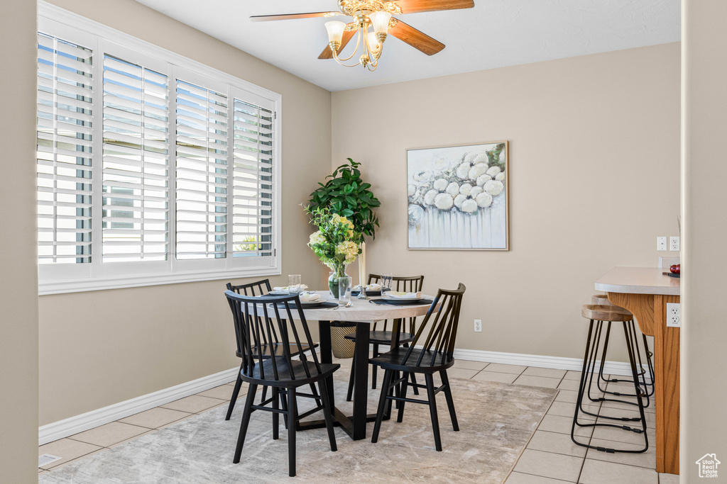 Dining room with tile patterned flooring, ceiling fan, and baseboards