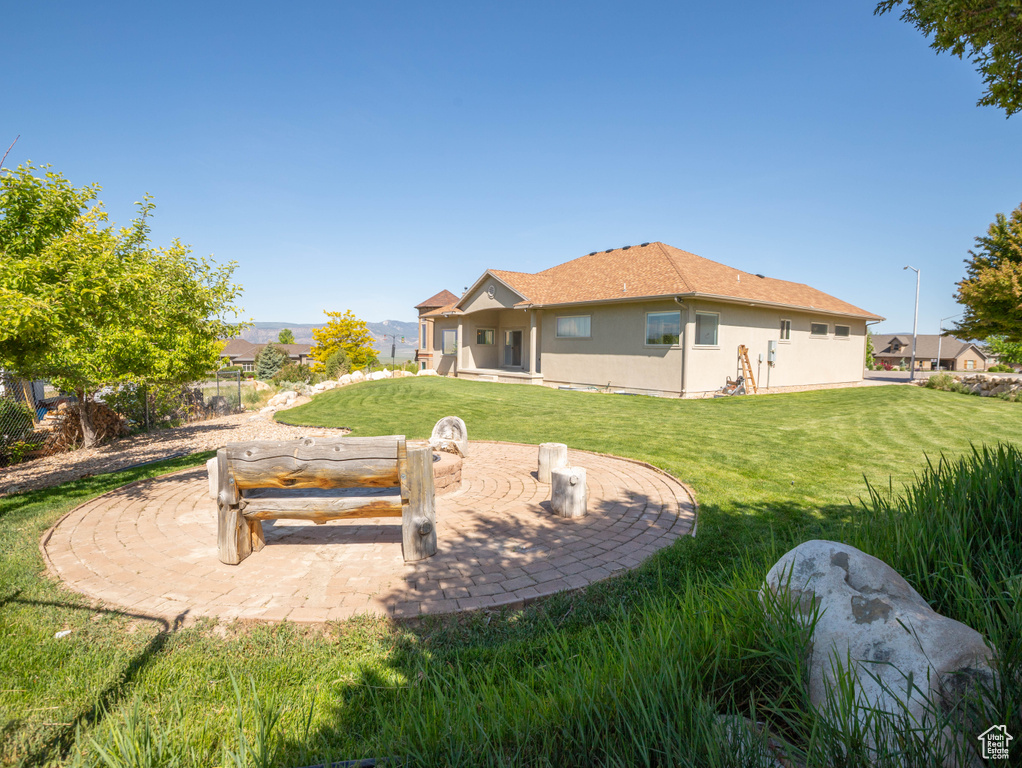 Back of property with stucco siding, a yard, and a patio area